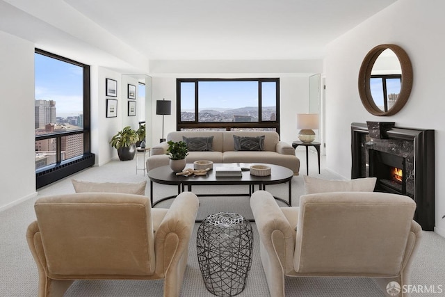 carpeted living room featuring a high end fireplace and plenty of natural light