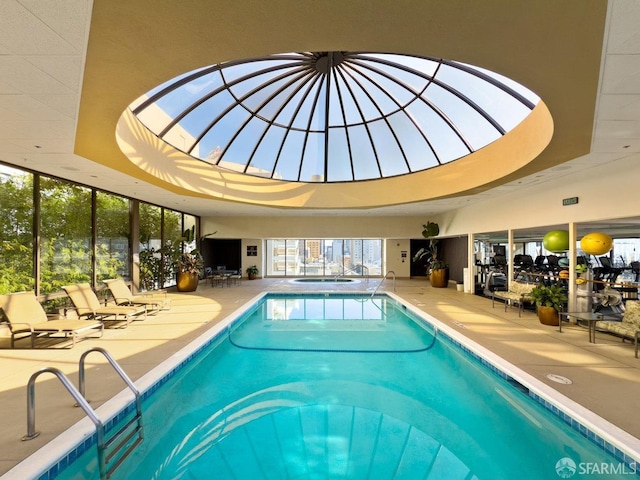 pool with glass enclosure, a patio area, and a community hot tub