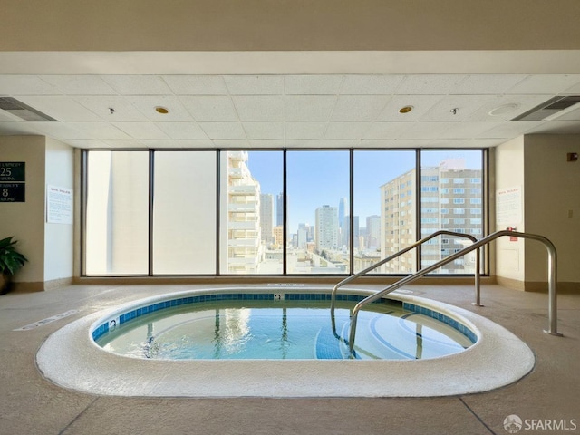 view of swimming pool with an indoor hot tub and a city view