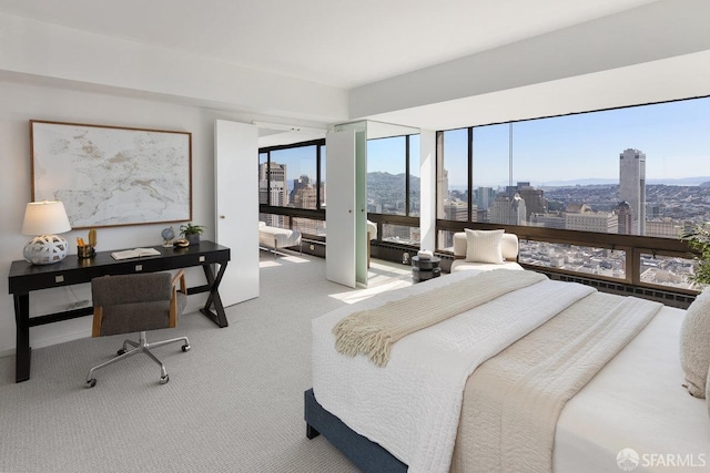 bedroom with a view of city, carpet floors, and access to outside