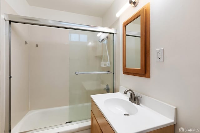 bathroom featuring vanity and a shower with door