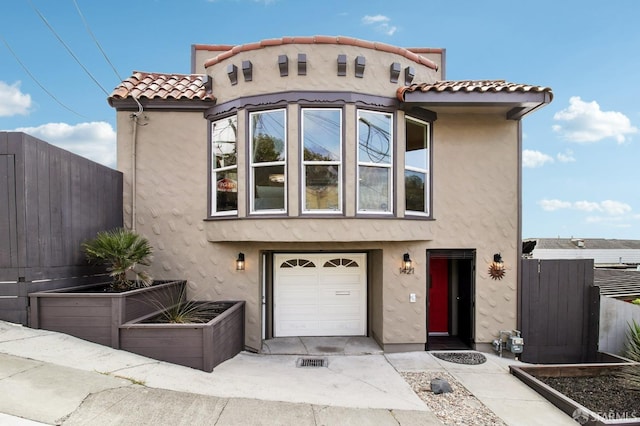 mediterranean / spanish-style home with stucco siding, fence, and a tiled roof