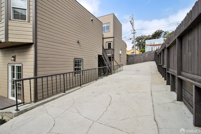 view of property exterior with fence and a patio