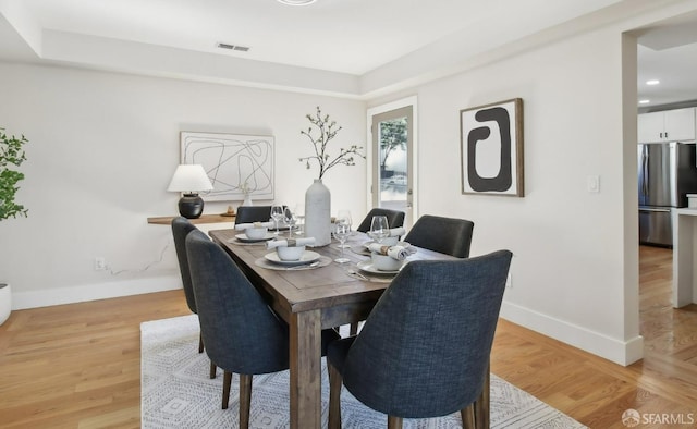 dining space with baseboards, light wood finished floors, and recessed lighting