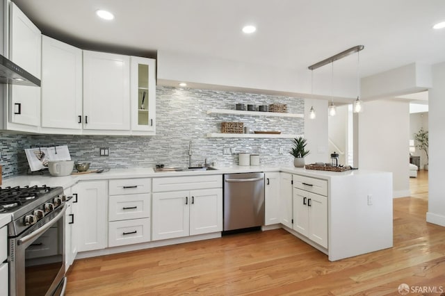 kitchen with stainless steel appliances, decorative backsplash, a sink, white cabinetry, and recessed lighting