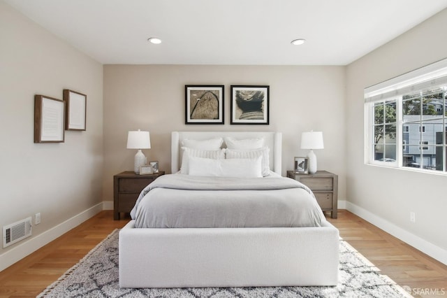 bedroom featuring baseboards, light wood-style flooring, and recessed lighting