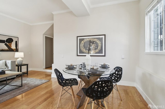 dining room with wood finished floors, baseboards, and crown molding