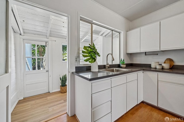 32-34 Gough St, San Francisco, CA 94103 - kitchen with a sink, light wood-style floors, dark countertops, and white cabinetry