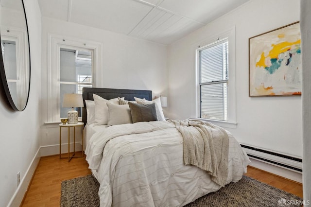 32-34 Gough St, San Francisco, CA 94103 - bedroom featuring a baseboard heating unit, wood finished floors, and baseboards