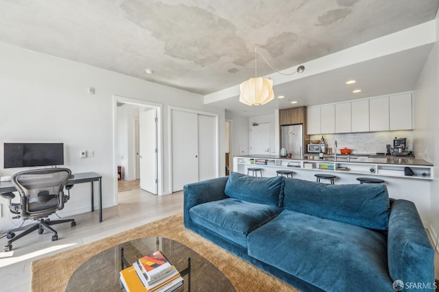 living area featuring recessed lighting, light wood-type flooring, and baseboards