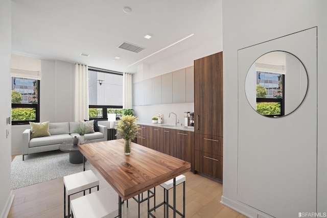 dining space with light hardwood / wood-style floors and sink