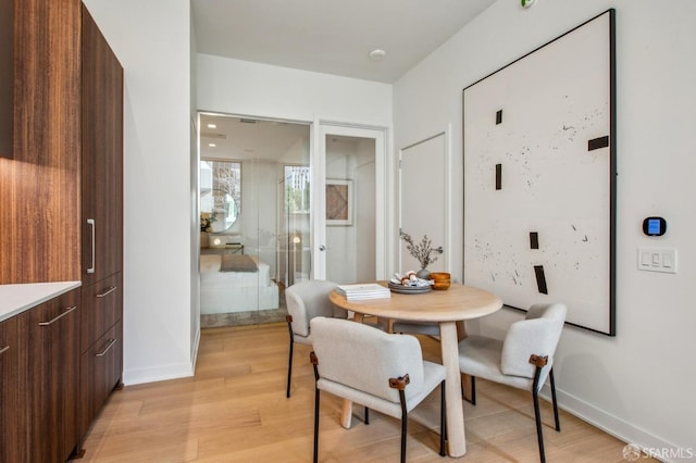 dining space featuring baseboards and light wood-style floors