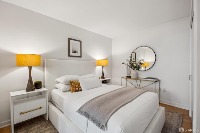 bedroom featuring baseboards and dark wood finished floors