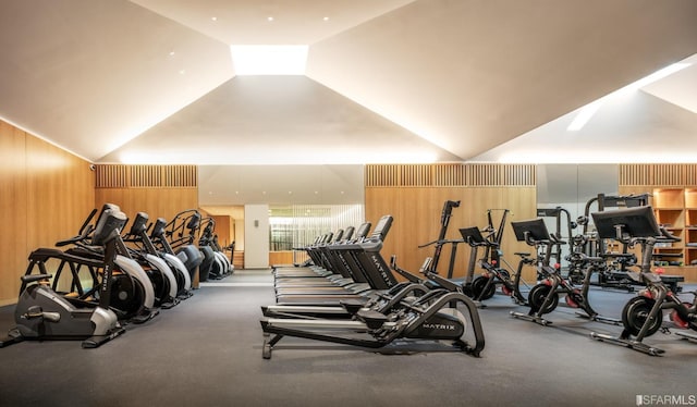 workout area with wooden walls and vaulted ceiling