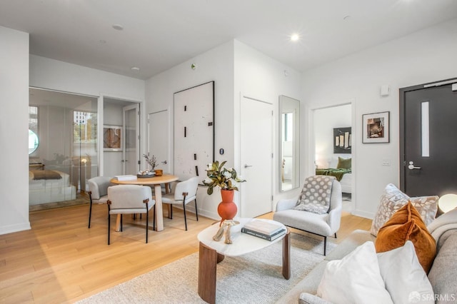 living room featuring recessed lighting, light wood-type flooring, and baseboards