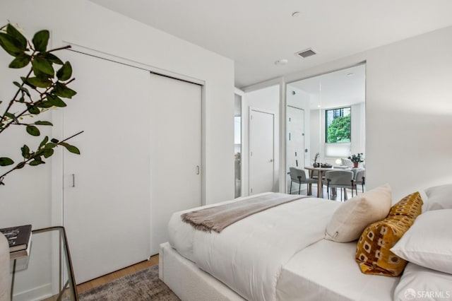 bedroom featuring wood finished floors and visible vents