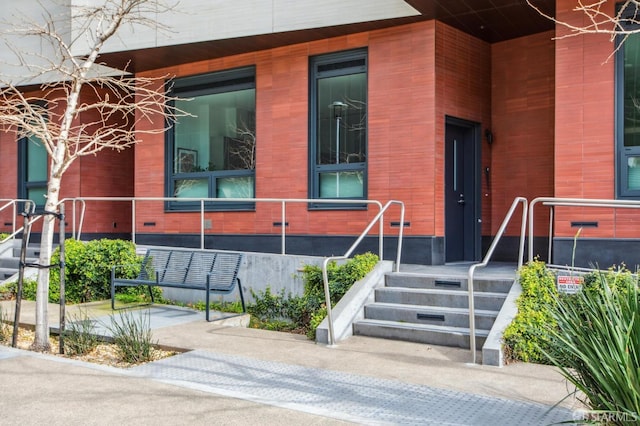 view of exterior entry featuring brick siding