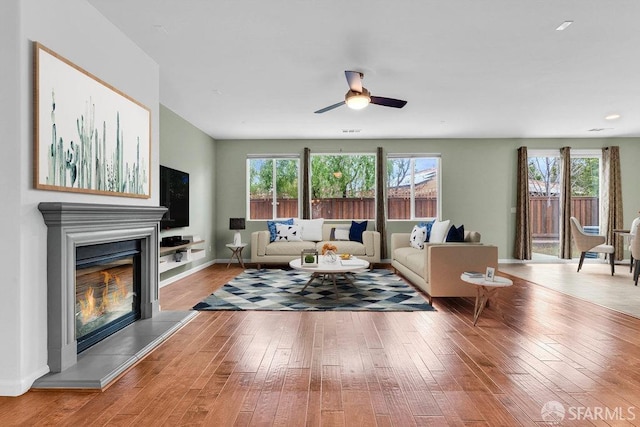 living room with plenty of natural light, light hardwood / wood-style floors, and ceiling fan