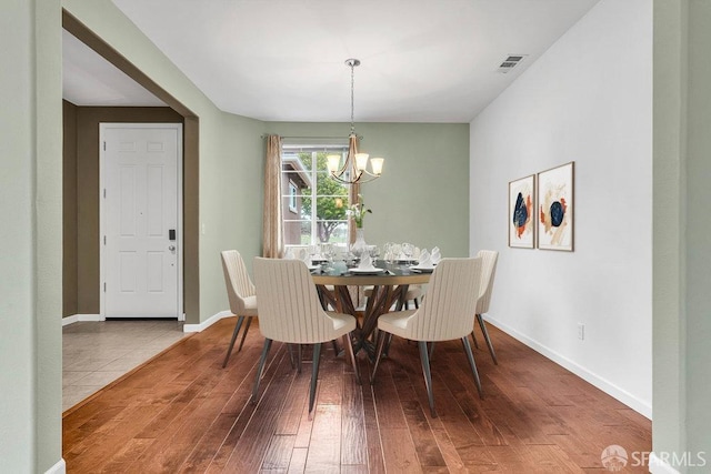 dining room with a notable chandelier and light wood-type flooring