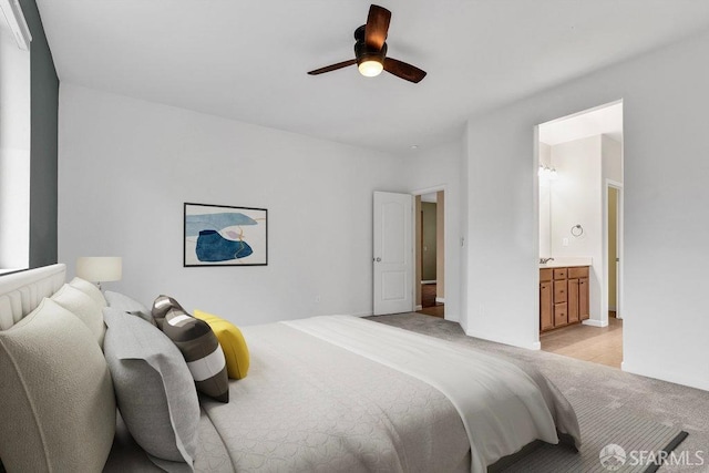 bedroom featuring light carpet, ceiling fan, and ensuite bathroom