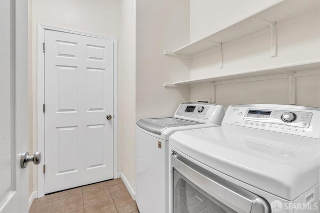 clothes washing area with independent washer and dryer and light tile patterned floors