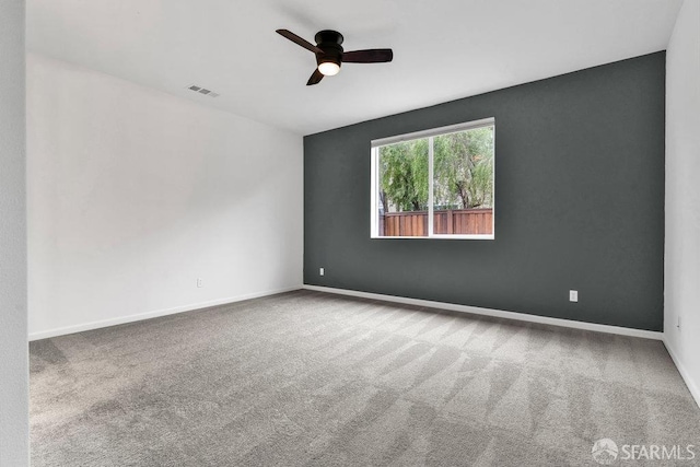 carpeted spare room featuring ceiling fan