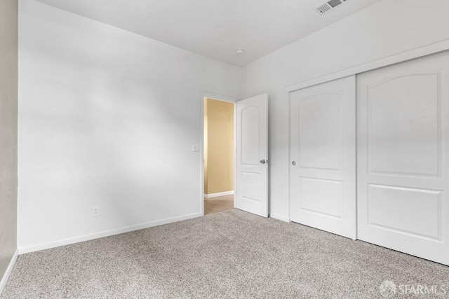 unfurnished bedroom with light carpet and a closet