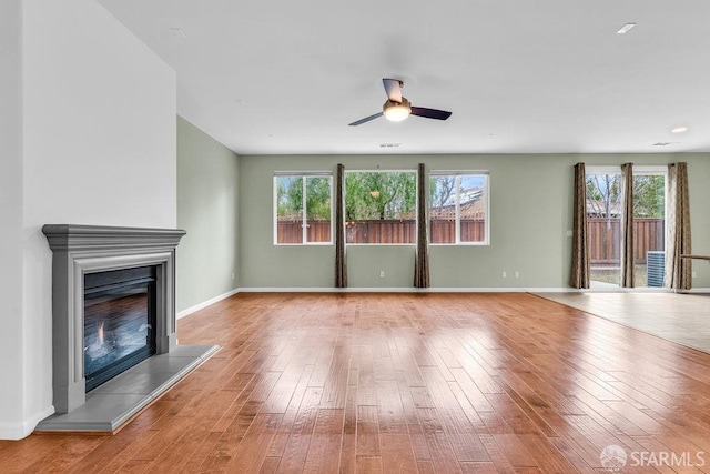 unfurnished living room featuring ceiling fan and light hardwood / wood-style flooring