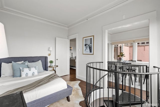 bedroom featuring ornamental molding, baseboards, and wood finished floors