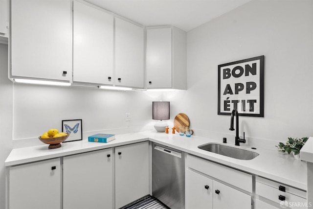 kitchen featuring light countertops, stainless steel dishwasher, and white cabinetry