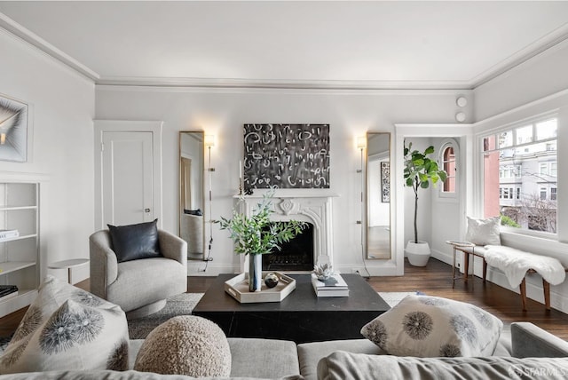 living area with baseboards, a premium fireplace, dark wood finished floors, and crown molding