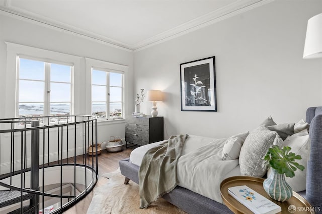 bedroom featuring ornamental molding and wood finished floors