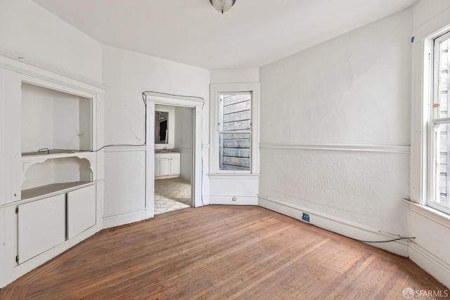 empty room featuring hardwood / wood-style flooring and a textured wall