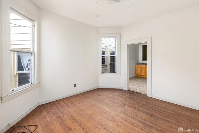 unfurnished room featuring baseboards and hardwood / wood-style floors