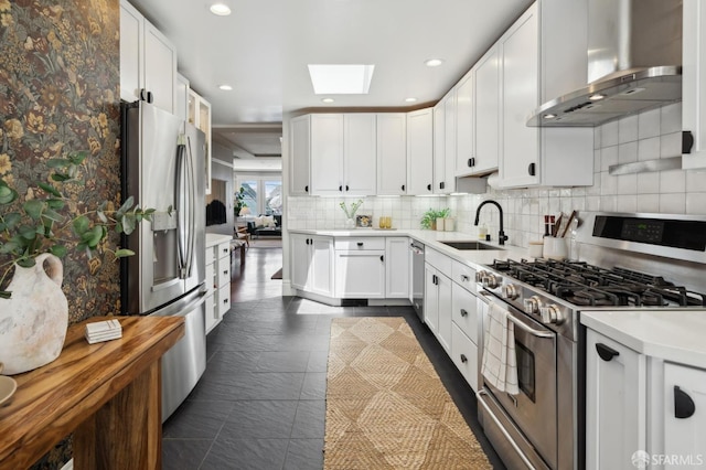24 Mirabel Ave, San Francisco, CA 94110 - kitchen featuring appliances with stainless steel finishes, wall chimney range hood, a sink, a skylight, and light countertops