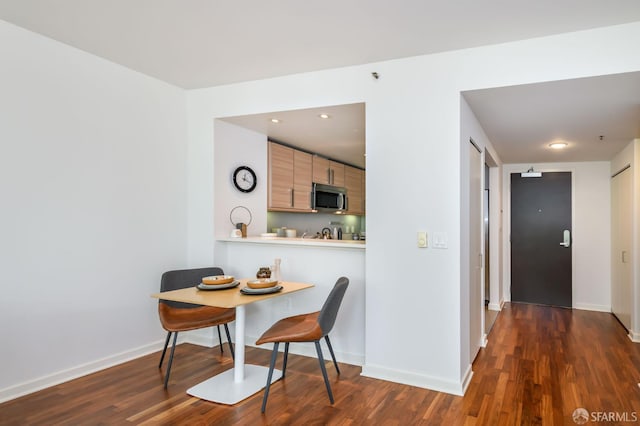 dining area with dark wood-style floors and baseboards