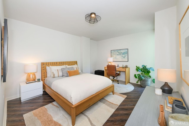 bedroom with wood finished floors, baseboards, and a desk