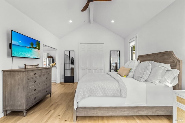 bedroom with ceiling fan, light hardwood / wood-style floors, a closet, and vaulted ceiling with beams