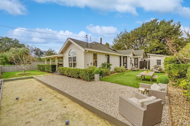 rear view of house featuring a patio area, outdoor lounge area, a yard, and a storage unit