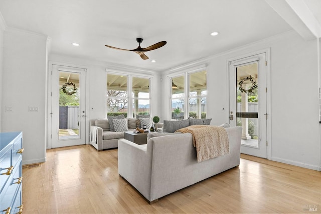 living room with ceiling fan, a wealth of natural light, and ornamental molding