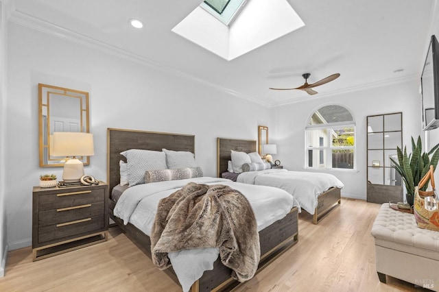 bedroom with ceiling fan, a skylight, and ornamental molding