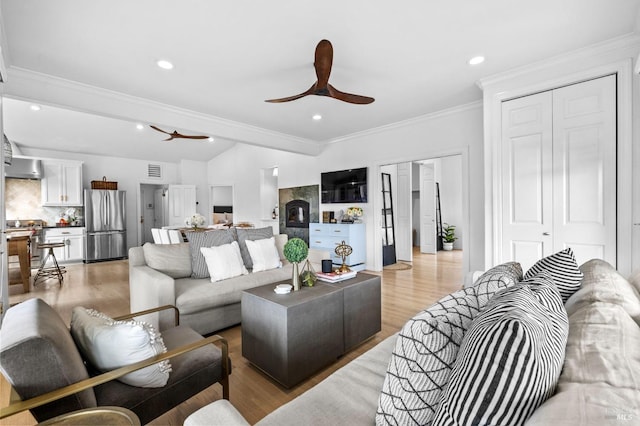 living room with ceiling fan, lofted ceiling, light hardwood / wood-style flooring, and ornamental molding