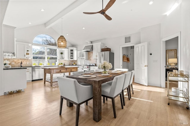 dining area with ceiling fan, beam ceiling, light hardwood / wood-style flooring, and high vaulted ceiling