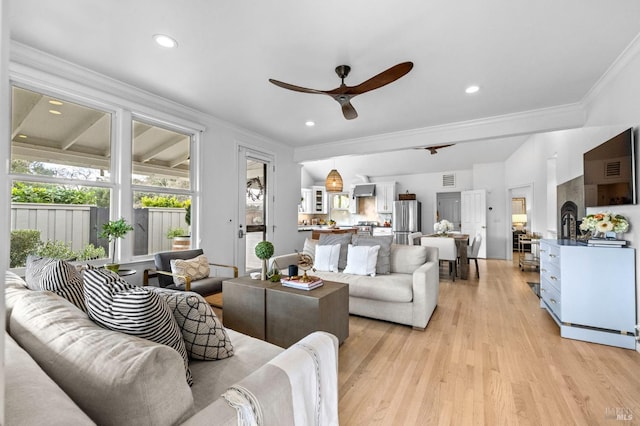 living room with ceiling fan, crown molding, and light wood-type flooring