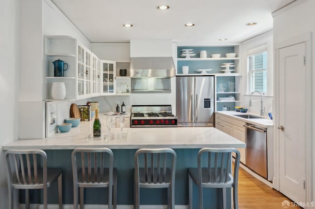 2932 Baker St, San Francisco, CA 94123 - kitchen featuring open shelves, appliances with stainless steel finishes, a sink, a peninsula, and a breakfast bar area