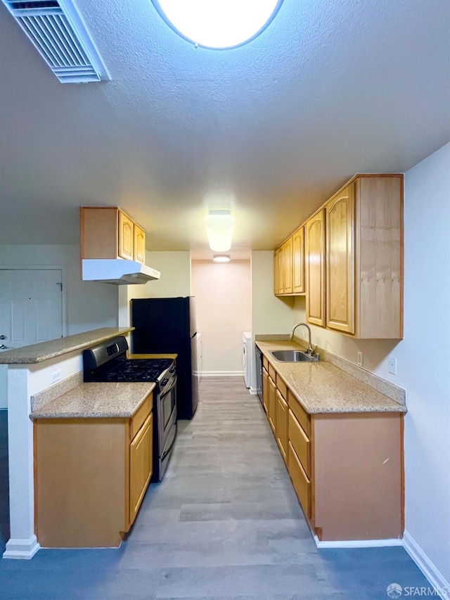 kitchen with kitchen peninsula, light brown cabinetry, stainless steel range, sink, and light hardwood / wood-style flooring