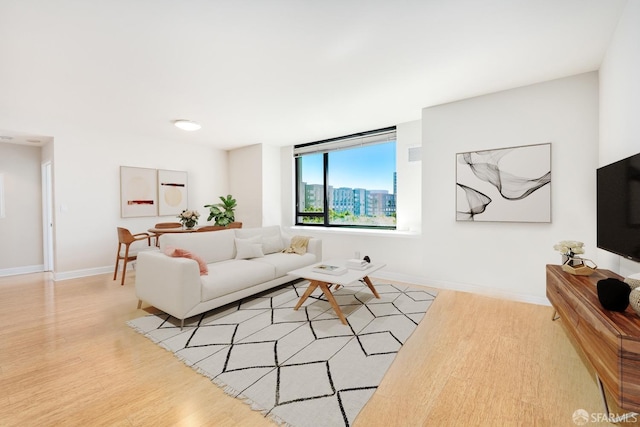 living area with light wood-type flooring and baseboards