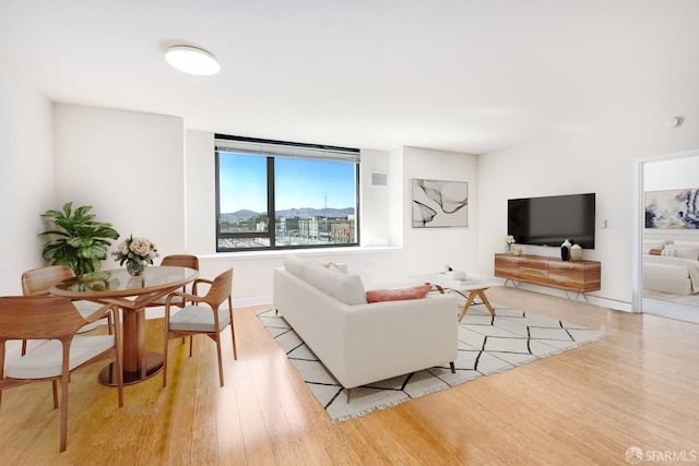 living room with light wood-style flooring and visible vents