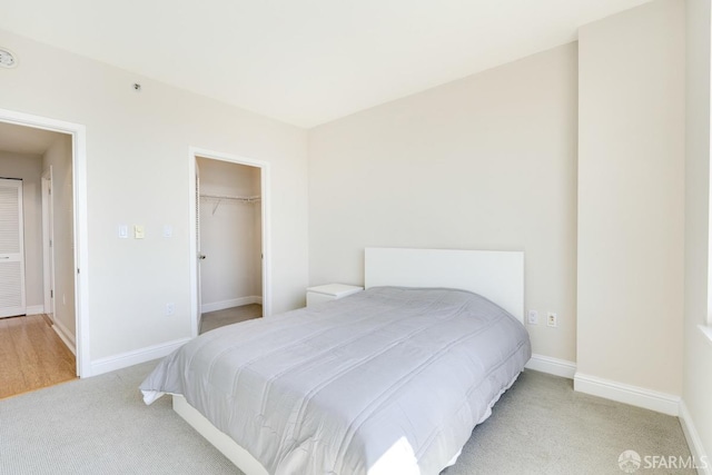 carpeted bedroom with a spacious closet and a closet