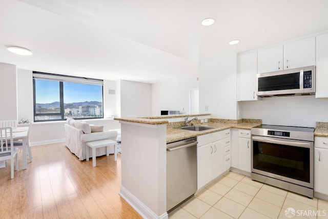 kitchen featuring white cabinetry, sink, kitchen peninsula, and stainless steel appliances